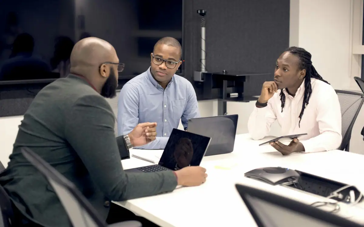 Team meeting around a table with laptops
